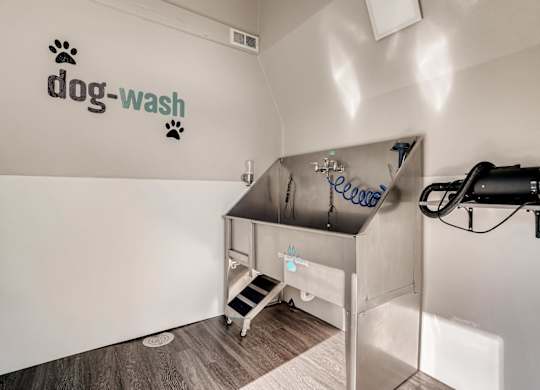 A dog wash station with a sign on the wall at The Ranch at Bear Creek Apartments, Colorado