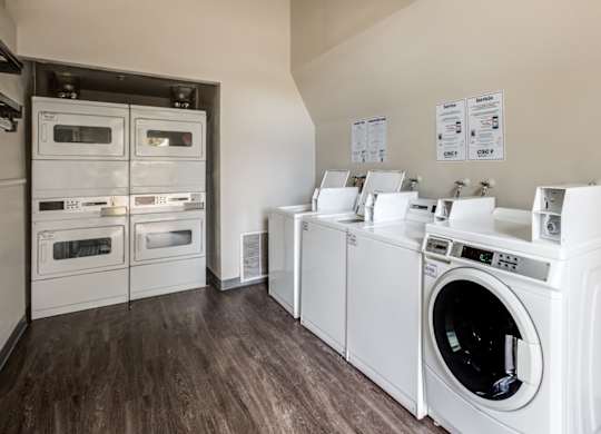 A row of white front load washing machines in a laundry room at The Ranch at Bear Creek Apartments, Lakewood, Colorado
