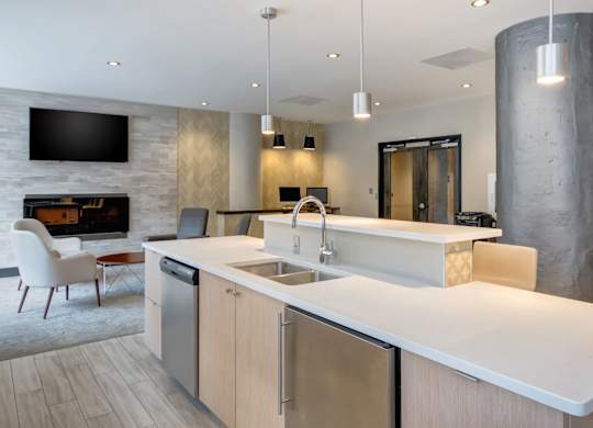 A modern kitchen with a white countertop and stainless steel appliances.