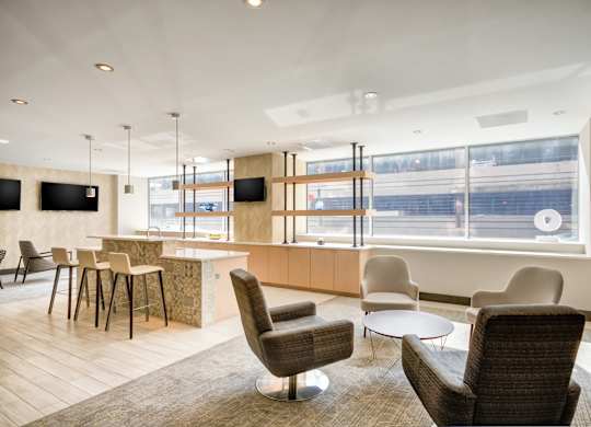 A modern waiting room with a large window and comfortable seating.