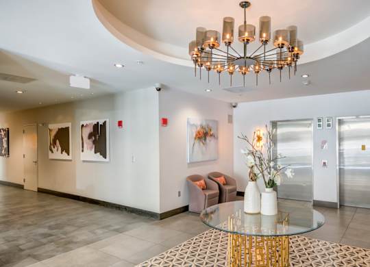 A modern interior with a glass table and a chandelier.