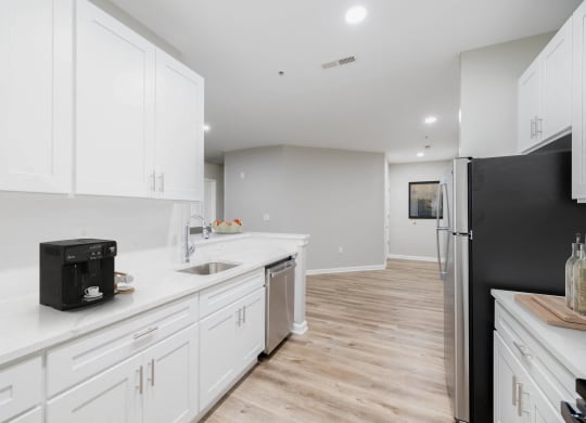 a white kitchen with white cabinets and a black refrigerator at The Lena, Raritan, NJ 08869