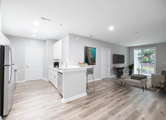 an open kitchen and living room with white walls and wood floors at The Lena, Raritan, NJ 08869