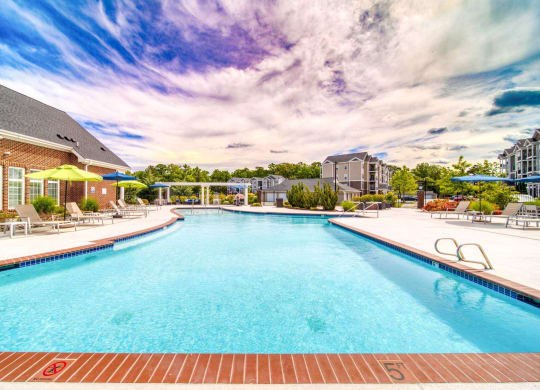 a swimming pool with lounge chairs at Meridian Obici, Suffolk, 23434