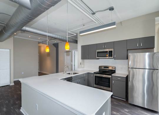 A modern kitchen with stainless steel appliances and a white island.