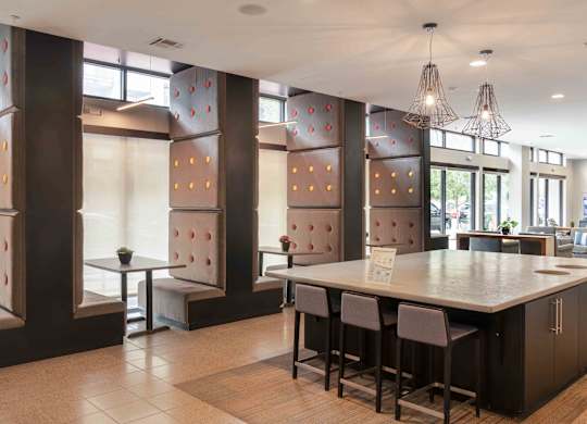 A modern kitchen with a long island and bar stools at Regatta Sloans Lake Apartments, Colorado