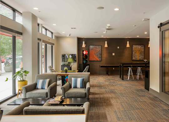 A modern waiting room with grey couches and a wooden floor at Regatta Sloans Lake Apartments, Denver 80204
