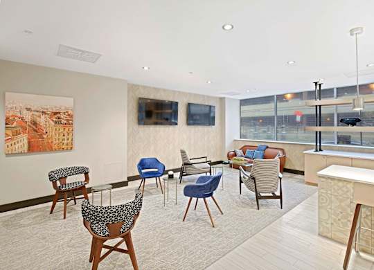 A living room with a large painting of a cityscape on the wall and a row of chairs in front of it.