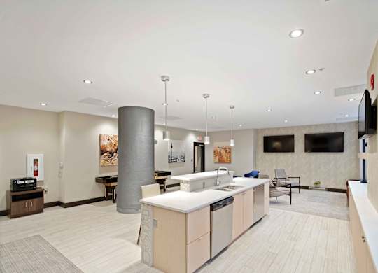 A modern kitchen with a large island and pendant lights.
