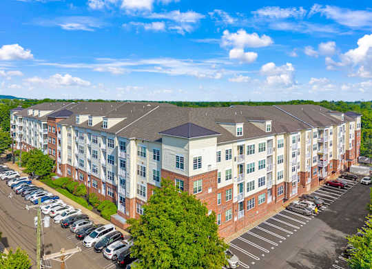 A large apartment complex with a parking lot in front.