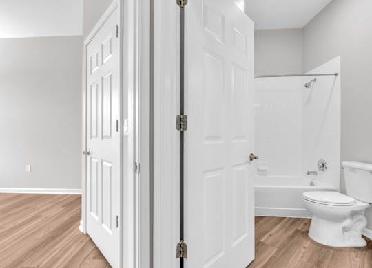A white bathroom with a toilet and a shower.
