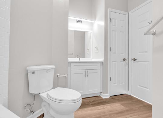 A white toilet with a tank and a white sink in a bathroom.