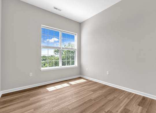 A room with a large window and wooden flooring.