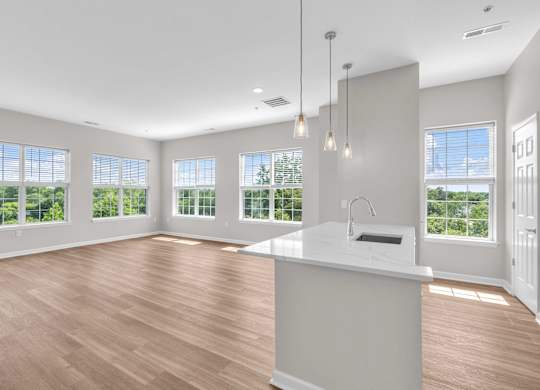 A kitchen with a large island and pendant lights.