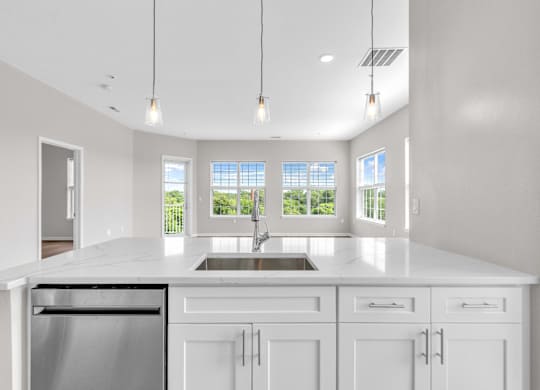 A modern kitchen with white cabinets and a large island.