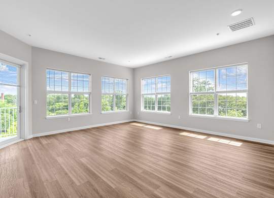 A room with wooden floors and large windows.