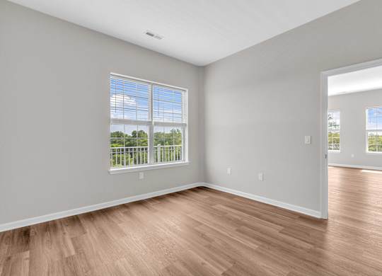 A room with wooden floors and a large window.
