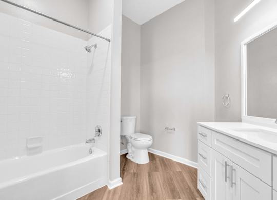 A white bathroom with a tub, toilet, and sink.