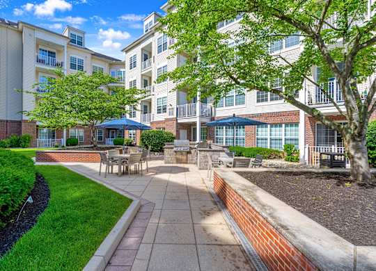 A sunny day at a residential complex with a well-maintained garden and seating area.