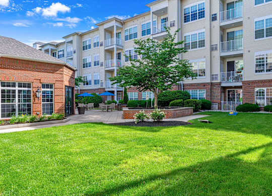 A large grassy area in front of apartment buildings.