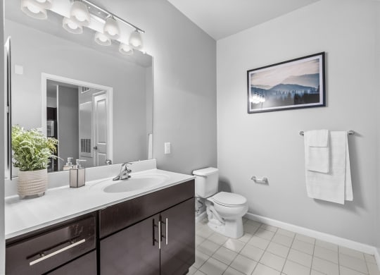 a bathroom with a toilet sink and mirror  at Harbor Pointe, Bayonne, New Jersey