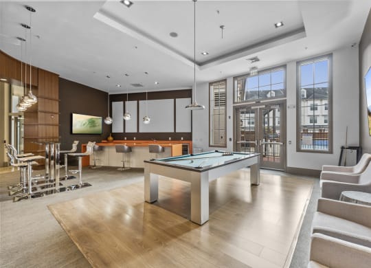 The Clubhouse with a pool table, entrance to outdoor pool, a bar and kitchen at Harbor Pointe, New Jersey, 07002