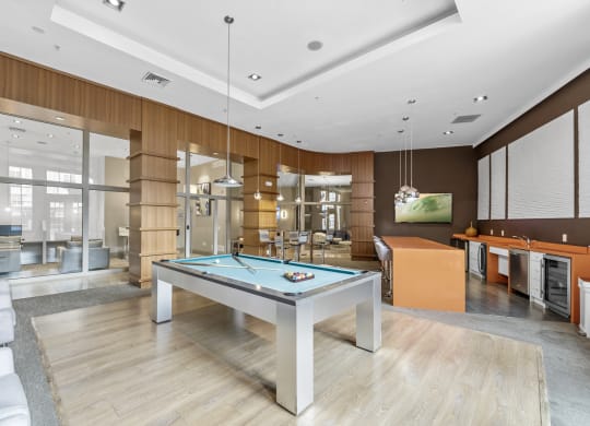 The Clubhouse with a pool table, entrance to outdoor pool, a bar and kitchen at Harbor Pointe, New Jersey, 07002