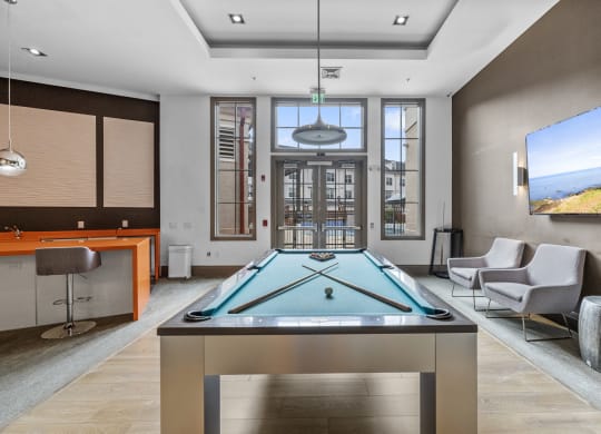 The Clubhouse with a pool table, entrance to outdoor pool, a bar and kitchen at Harbor Pointe, New Jersey, 07002