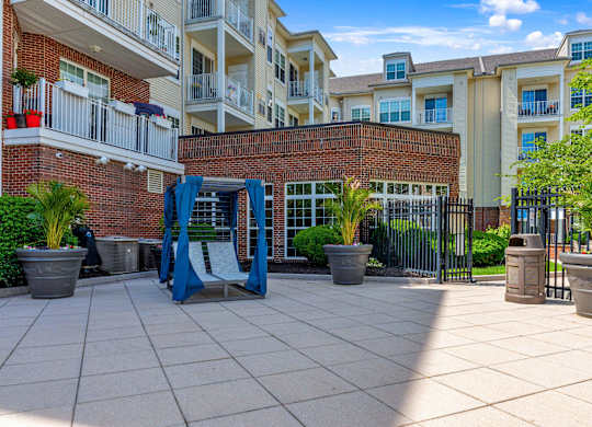 A playground area with a slide and potted plants in front of apartment buildings.