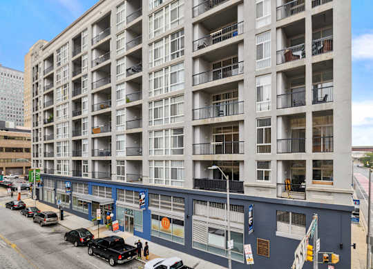 A large apartment building with balconies and a blue awning.