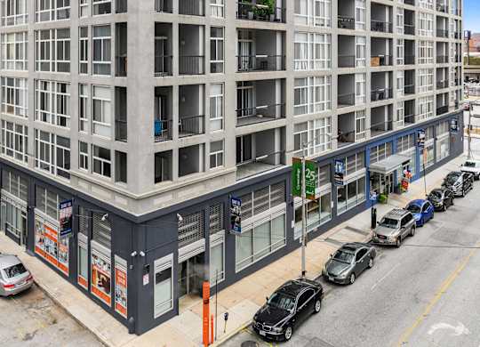 A street view of a building with cars parked in front.