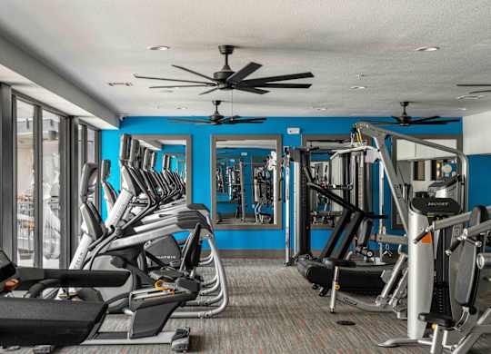 A gym with treadmills, weights, and a fan at Regatta Sloans Lake Apartments, Denver, Colorado