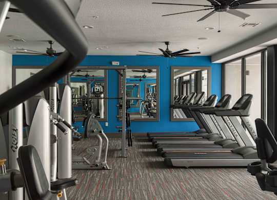 A gym with treadmills, weights, and a fan at Regatta Sloans Lake Apartments, Denver, CO, 80204