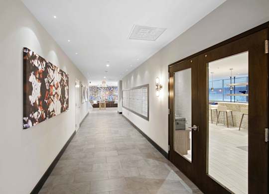 A hallway with a brown door and a painting on the wall.