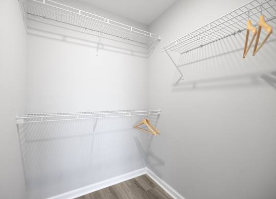 A white closet with a hanger on the left side.