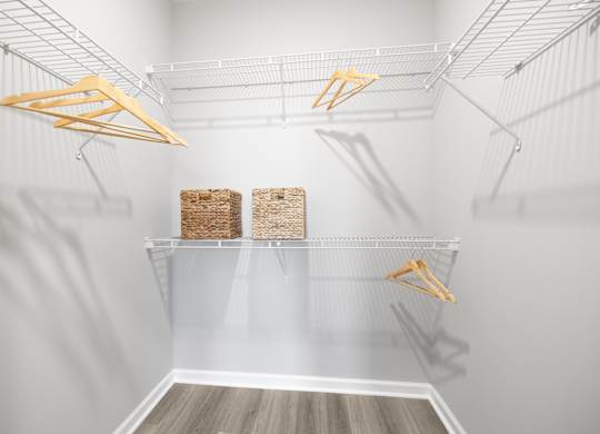 A white pantry with two shelves and hangers.