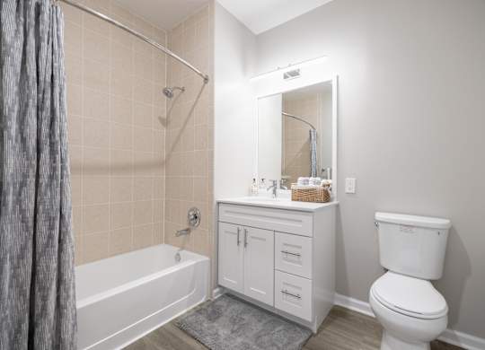 A white bathroom with a toilet, sink, and bathtub.