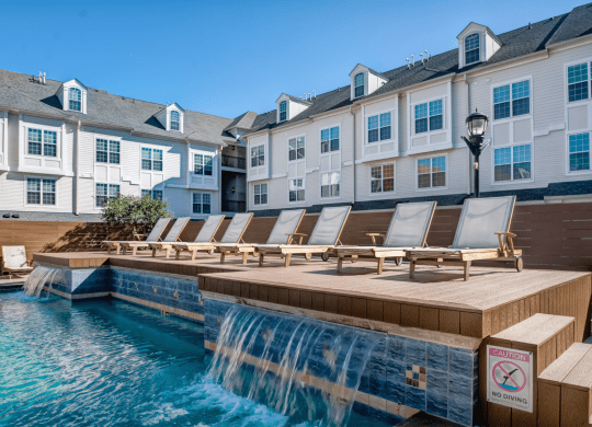 a pool with a waterfall and a row of lounge chairs at Harbor Pointe  at Harbor Pointe, Bayonne, NJ, 07002