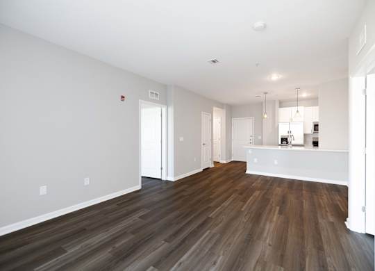 A room with wooden flooring and white walls.