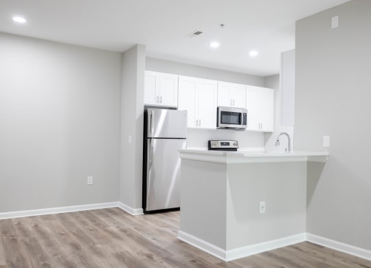 a kitchen with white cabinets and a stainless steel refrigerator at The Lena, Raritan, NJ 08869