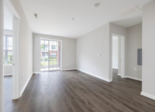 an empty living room with white walls and wood flooring at The Lena, Raritan, NJ 08869