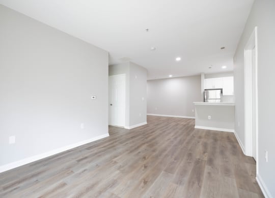 an empty living room with white walls and wood flooring at The Lena, Raritan, NJ 08869