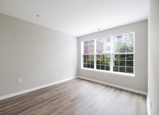 an empty room with wood floors and a large window at The Lena, Raritan, NJ 08869