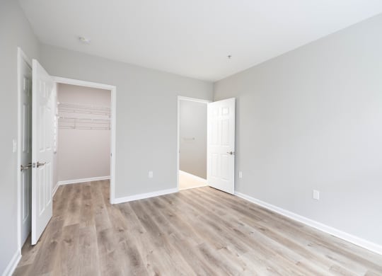 an empty room with white walls and wood flooring at The Lena, Raritan, NJ 08869