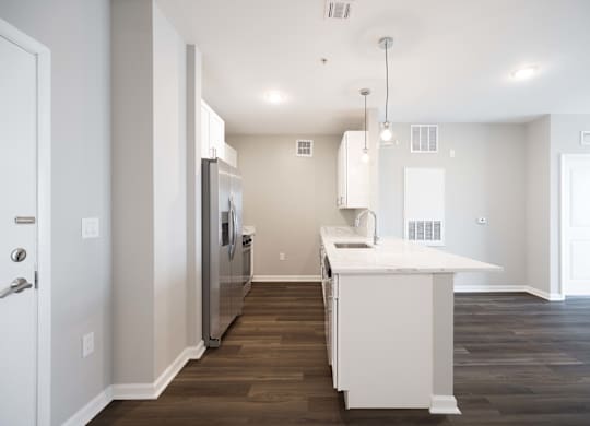 A kitchen with a white island and stainless steel appliances.