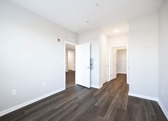 A room with wood flooring and white walls.