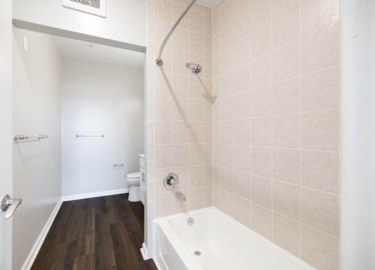 A white bathroom with a tub and toilet.