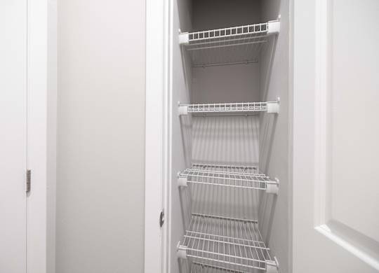 Empty white shelves in a white pantry.