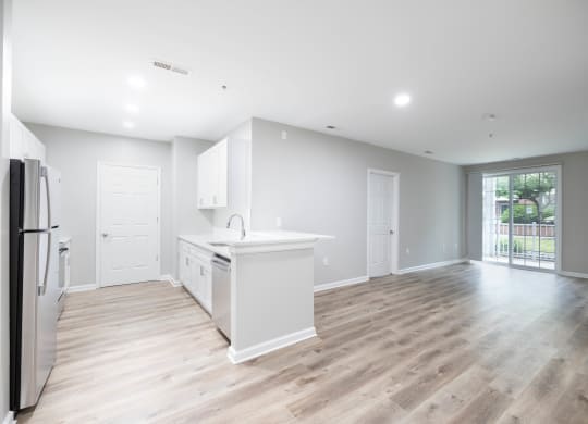 an empty kitchen and living room with a refrigerator and a sink at The Lena, Raritan, NJ 08869
