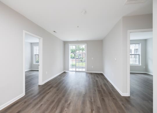 an empty living room with white walls and wood floors at The Lena, Raritan, NJ 08869